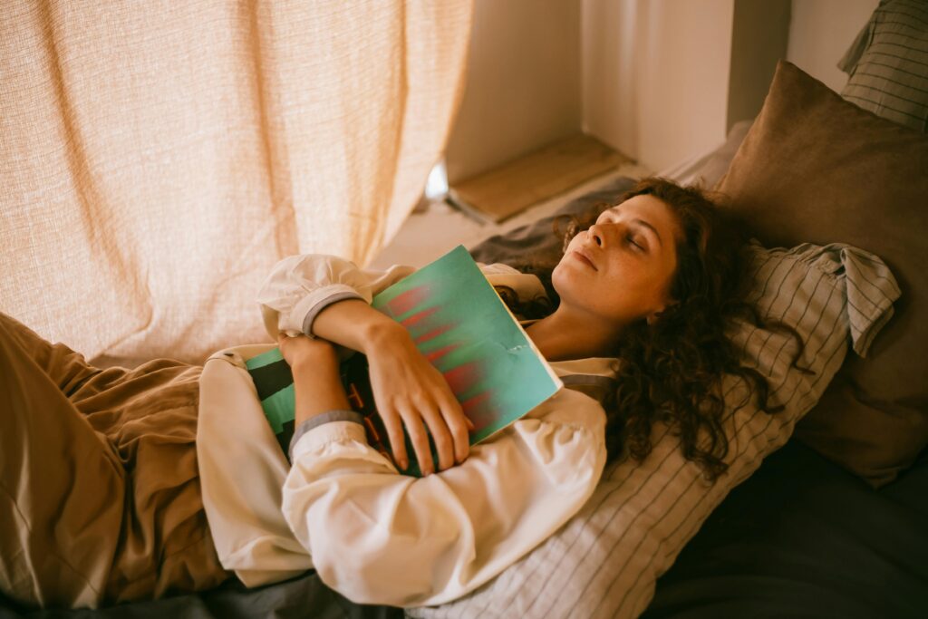 A teenager relaxing in a cozy bedroom while hugging a vinyl record, eyes closed.