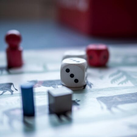 Close-up view of board game pieces and dice on a game board. Perfect for recreation and strategy themes.